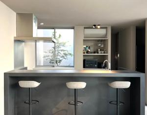 a kitchen with two bar stools at a counter at Lix in Futtsu