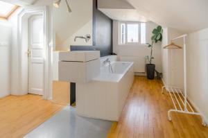 a white bathroom with a sink and a tub at Historic Centre Apartments I in Prague