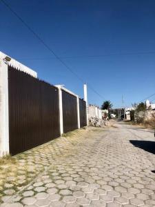 uma cerca ao lado de uma estrada de tijolos em Casa amplia y Cómoda em Chapulco