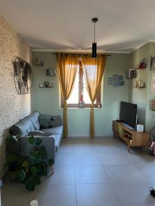een woonkamer met een bank en een raam bij Incanto e relax nel verde in Città della Pieve
