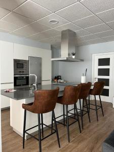 a kitchen with a counter and bar stools at Fogar de Aurora in Portomarin
