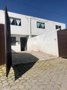 um edifício branco com um portão em frente em Casa amplia y Cómoda em Chapulco