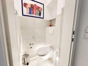 ein weißes Bad mit einem WC und einem Bild an der Wand in der Unterkunft W Apartment - Brigittenau Area MM29 in Wien