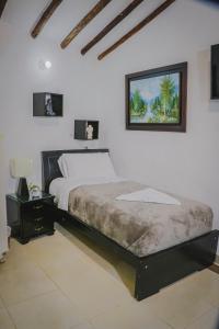 una camera con un letto e una foto appesa al muro di Mi Terruño a Barichara