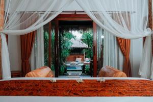 - une vue sur une chambre avec un lit et un miroir dans l'établissement Way Ubud House, à Ubud