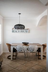 una sala da pranzo con tavolo, sedie e lampadario pendente di IT'S A SHORE THING - stay, relax, & enjoy! a Clearwater Beach