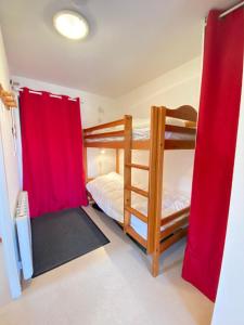 sypialnia z 2 łóżkami piętrowymi i czerwonymi zasłonami w obiekcie Nice ski nest in Dévoluy w mieście Dévoluy