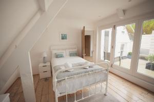 um quarto com uma cama branca e uma janela em Fairhaven em Dartmouth
