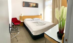a bedroom with a bed and a red chair at Corso in Eforie Sud