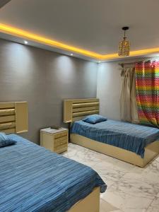 1 Schlafzimmer mit 2 Betten und einem Kronleuchter in der Unterkunft Grand Tower in Kairo