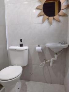 a bathroom with a toilet and a sink and a mirror at Suíte Verano 1,2,3 e 4 in Niterói