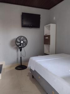 a bedroom with a fan next to a bed at Suíte Verano 1,2,3 e 4 in Niterói