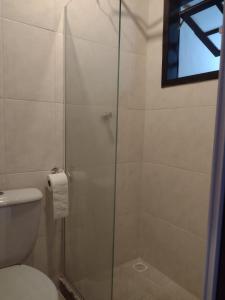 a bathroom with a glass shower with a toilet at Suíte Verano 1,2,3 e 4 in Niterói