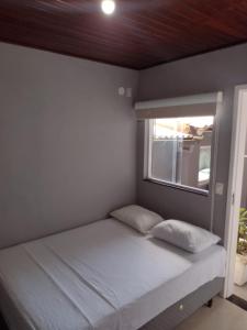 a small bedroom with a bed with a window at Suíte Verano 1,2,3 e 4 in Niterói