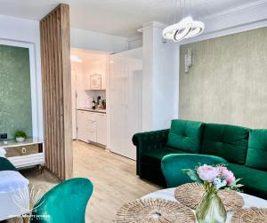 a living room with a green couch and a table at Heaven Infinity Sunrise Pool & SPA in Mamaia Sat/Năvodari