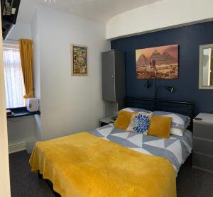 ブラックプールにあるHornby Villa 4*B&B Couples & Families Onlyのベッドルーム1室(黄色い毛布付きのベッド1台付)
