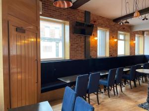 een eetkamer met blauwe stoelen en een bar bij The Royal Crest in Liverpool