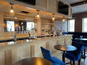 a bar in a restaurant with tables and chairs at The Royal Crest in Liverpool