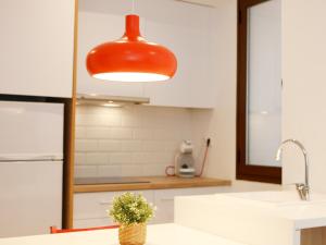 une cuisine avec une suspension rouge au-dessus d'un évier dans l'établissement Labradores 13, à Alicante 74 autres photos
