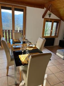 Un comedor con una mesa con copas de vino encima. en Joli T3 à la montagne, en Marignier