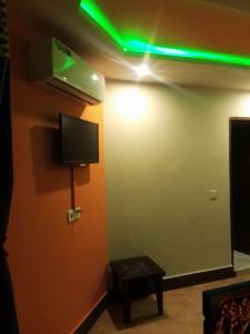 Cette chambre comprend une télévision et une lumière verte. dans l'établissement Executive Guest House, à Islamabad
