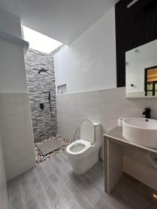 a bathroom with a toilet and a sink and a shower at Boli Villa Thoddoo in Thoddoo