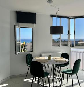 uma sala de jantar com uma mesa e cadeiras verdes em Jandia Beach Apartment 2 em Morro del Jable