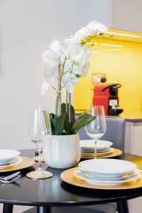 een tafel met borden en glazen en een vaas met witte bloemen bij Spitafields 2 Bed Shoreditch Apartment in Londen
