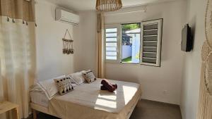 um quarto com uma cama e uma janela em Villa Maya & Villa Massaï em Le Marin