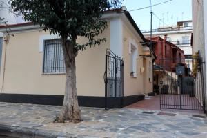 un árbol frente a un edificio con una puerta en Orfeas Home/Detached House 74m2,parking&yard, en Volos