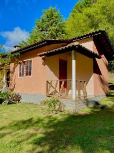 uma pequena casa com um alpendre num quintal em Pousada Rural Recanto do Lago em Pedra Azul