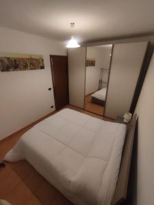 - une chambre avec un grand lit blanc et un miroir dans l'établissement Casa a 5 minuti dal centro di Tortona, à Tortone