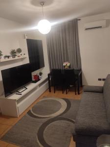 een woonkamer met een bank en een flatscreen-tv bij Casa a 5 minuti dal centro di Tortona in Tortona