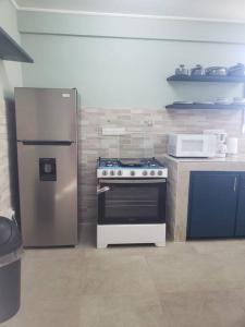 a kitchen with a stove and a refrigerator at Brand new spacious residence in Checkhall in Massacre