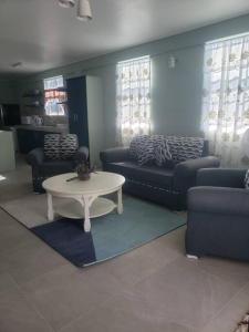 a living room with a couch and a table at Brand new spacious residence in Checkhall in Massacre