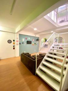 a living room with a couch and a staircase at Princesa Hostel in Belém