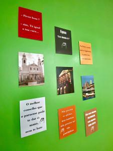 a green wall with pictures and signs on it at Princesa Hostel in Belém