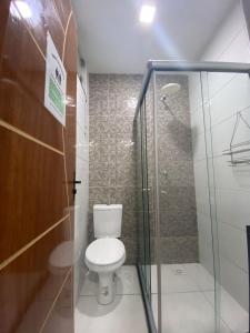 a bathroom with a toilet and a glass shower at Princesa Hostel in Belém