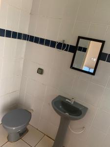 uma casa de banho com um WC azul e um espelho. em Hotel Pousada Lagoa Azul em Paranaíba