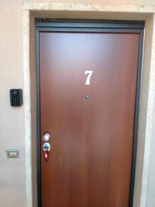 Uma porta castanha com o número sete. em Residenza Cornicello em Bardolino