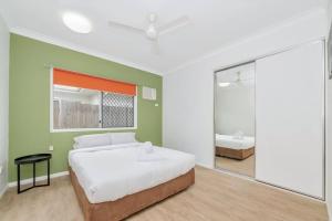 a bedroom with a bed and a mirror at 4 bed 2 bath home in Idalia in Oonoonba