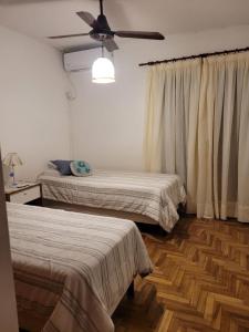 a bedroom with two beds and a ceiling fan at Mi casa vuelta de obligado 576 in Federación