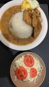 a plate of food with rice and a bowl of soup at Hotel Pousada Lagoa Azul in Paranaíba