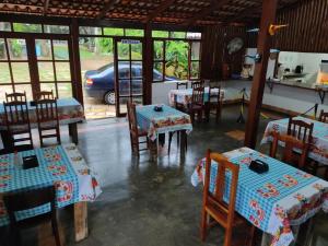 a dining room with tables and chairs and a car at Pousada Colonial in Pirenópolis