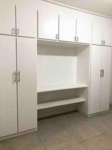 a white closet with white cabinets in a room at Encontro Open House in São Paulo