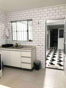 uma casa de banho branca com um lavatório e um espelho em Encontro Open House em São Paulo