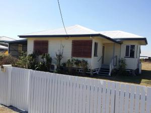 una casa blanca con una valla delante en 3 bed room house near airport, en North Ward
