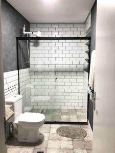 ein Badezimmer mit einem weißen WC und einer Dusche in der Unterkunft Encontro Open House in São Paulo