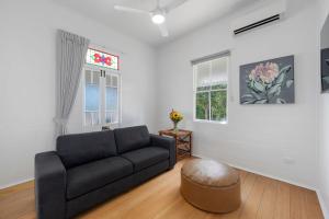 uma sala de estar com um sofá e uma janela em Charming 3-Bedroom Retreat em Townsville