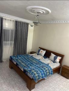 een slaapkamer met een bed en een kroonluchter bij Appartement meublé F4 Maristes, Dakar in Dakar